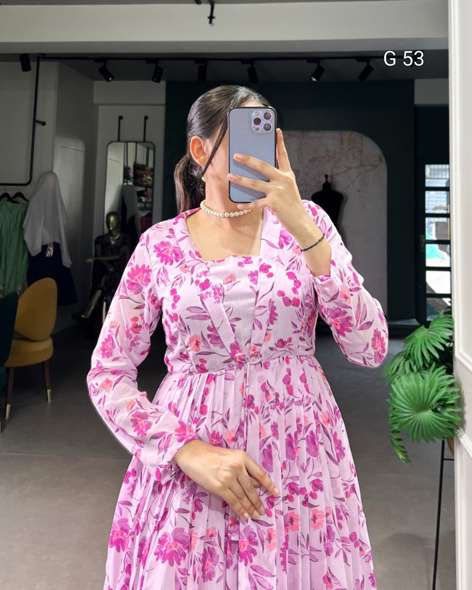 Person wearing a pink floral dress taking a mirror selfie in an indoor setting.
