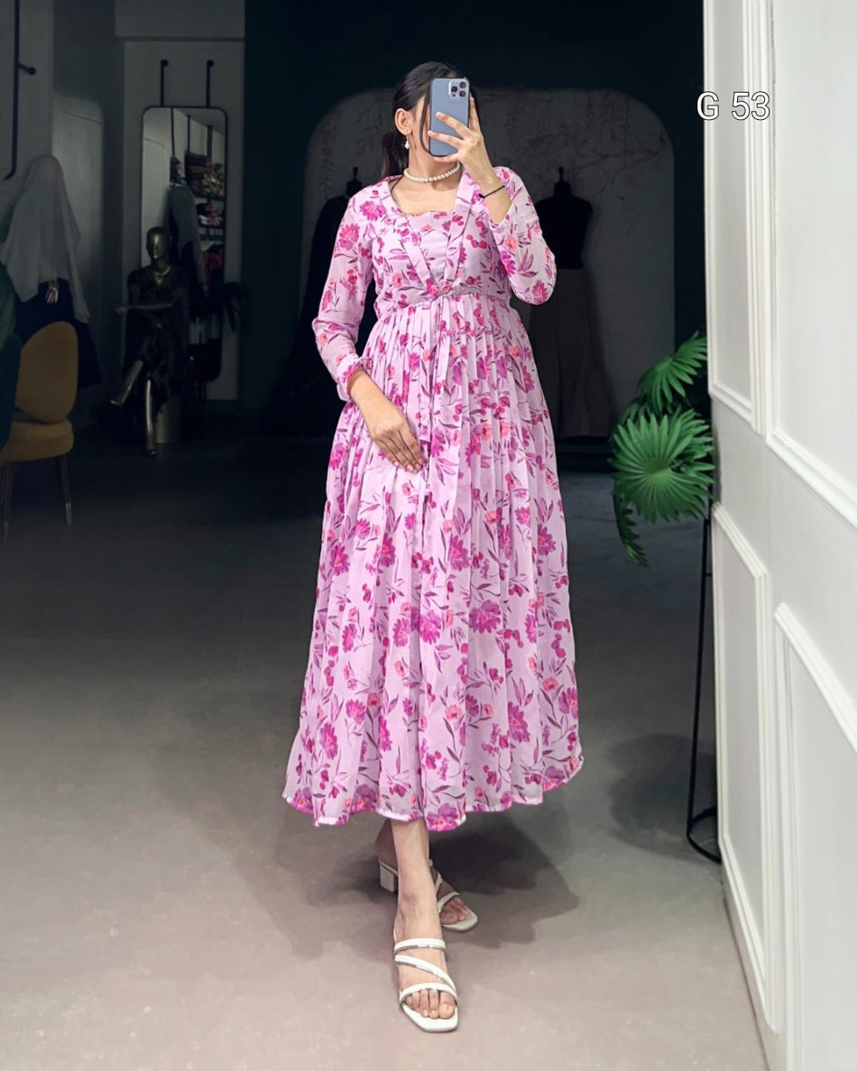 Person wearing a pink floral dress taking a mirror selfie in a room.