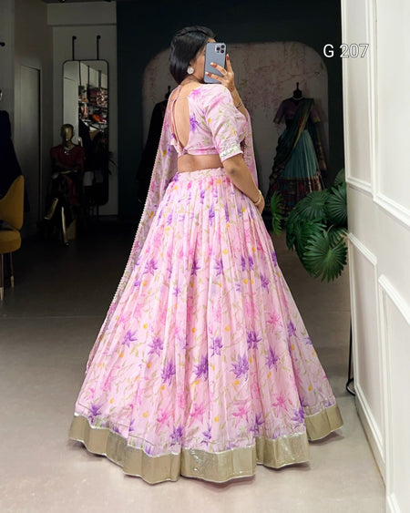 Woman in a pink floral saree taking a mirror selfie in a room.