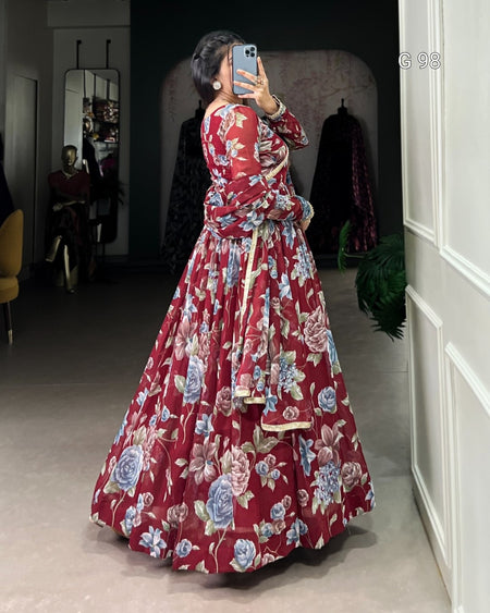 Person wearing a red floral dress taking a mirror selfie in a room.