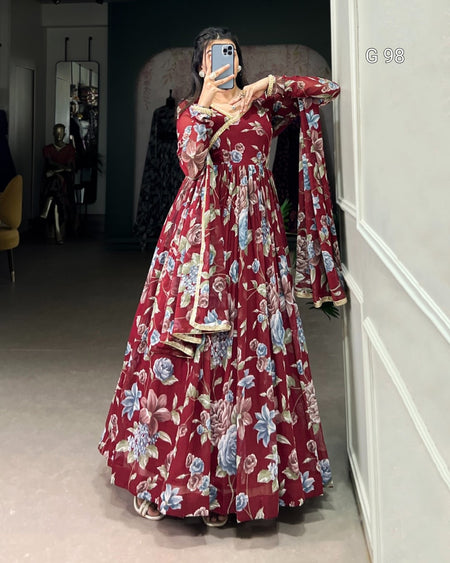 Person wearing a long floral dress taking a mirror selfie.