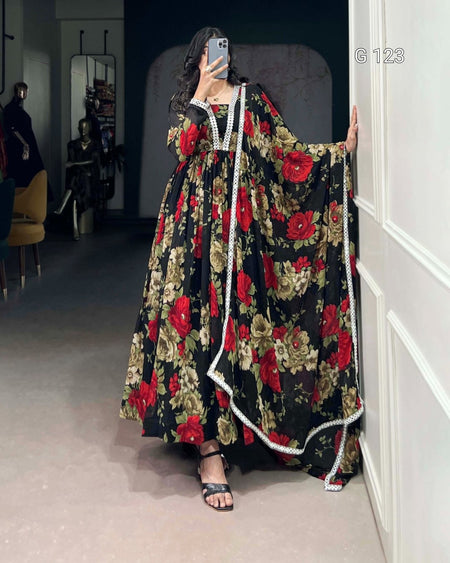 Person wearing a floral dress with red flowers in a room.