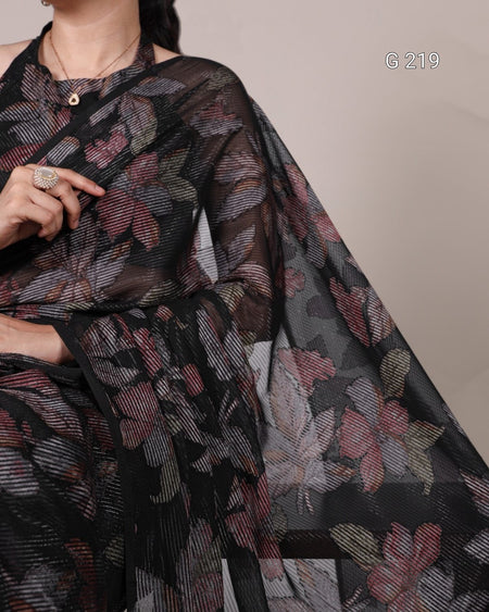 Black floral patterned fabric held by a person against a neutral background
