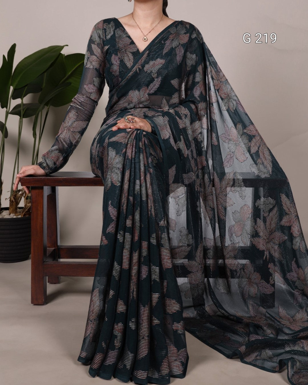 Woman wearing a floral saree with a plain background