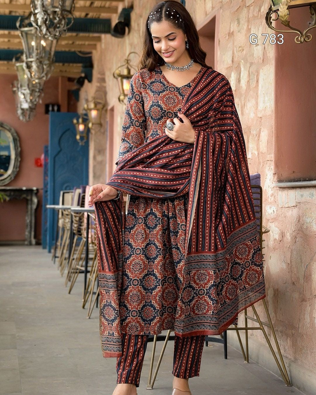 Woman wearing a patterned outfit in an ornate interior setting