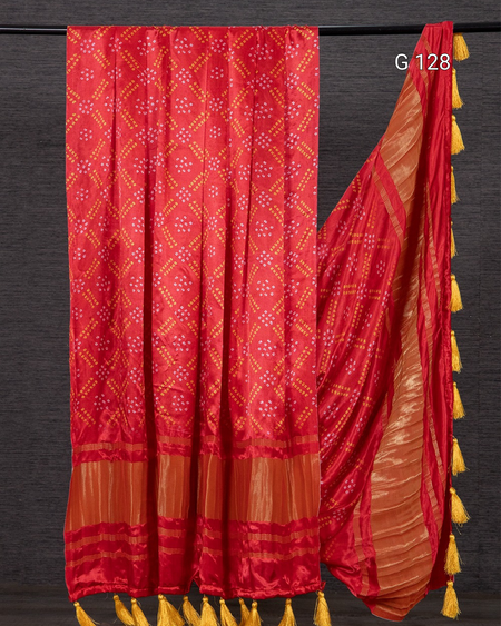 Red and orange saree with tassels on a dark background