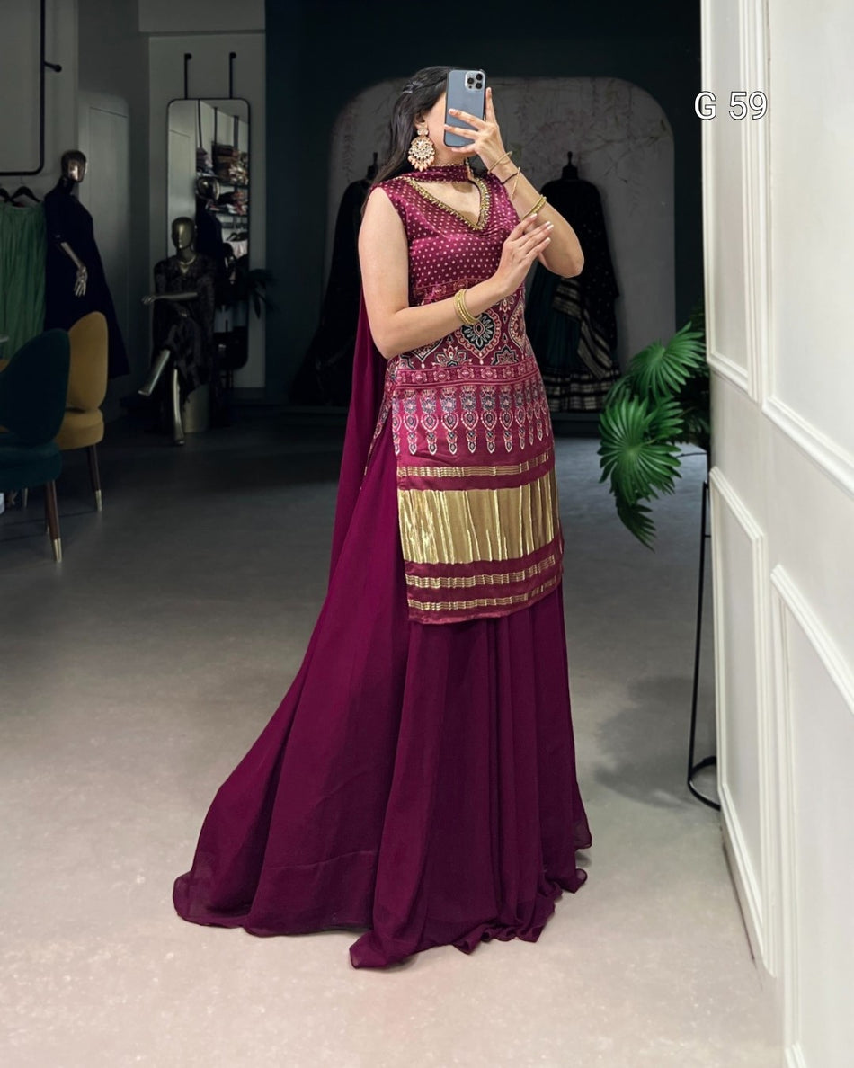 Woman taking a mirror selfie wearing a maroon and gold traditional outfit.