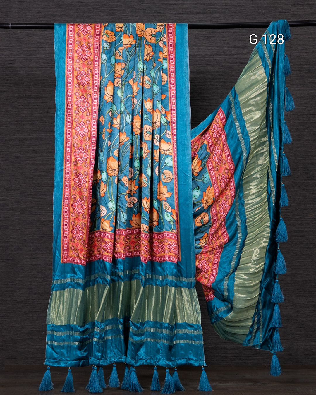 Colorful saree with floral patterns and tassels on a dark background