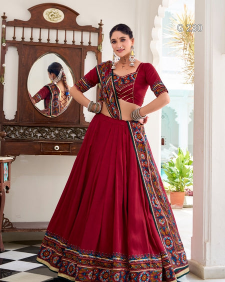 Woman in a red traditional outfit with intricate patterns in a decorated room.