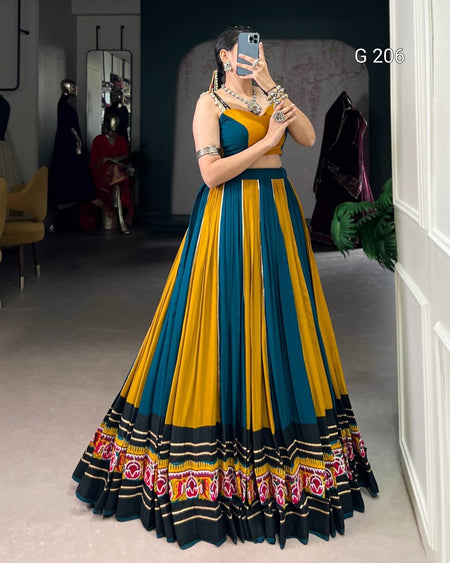 Woman wearing a blue and yellow traditional outfit with floral patterns indoors.