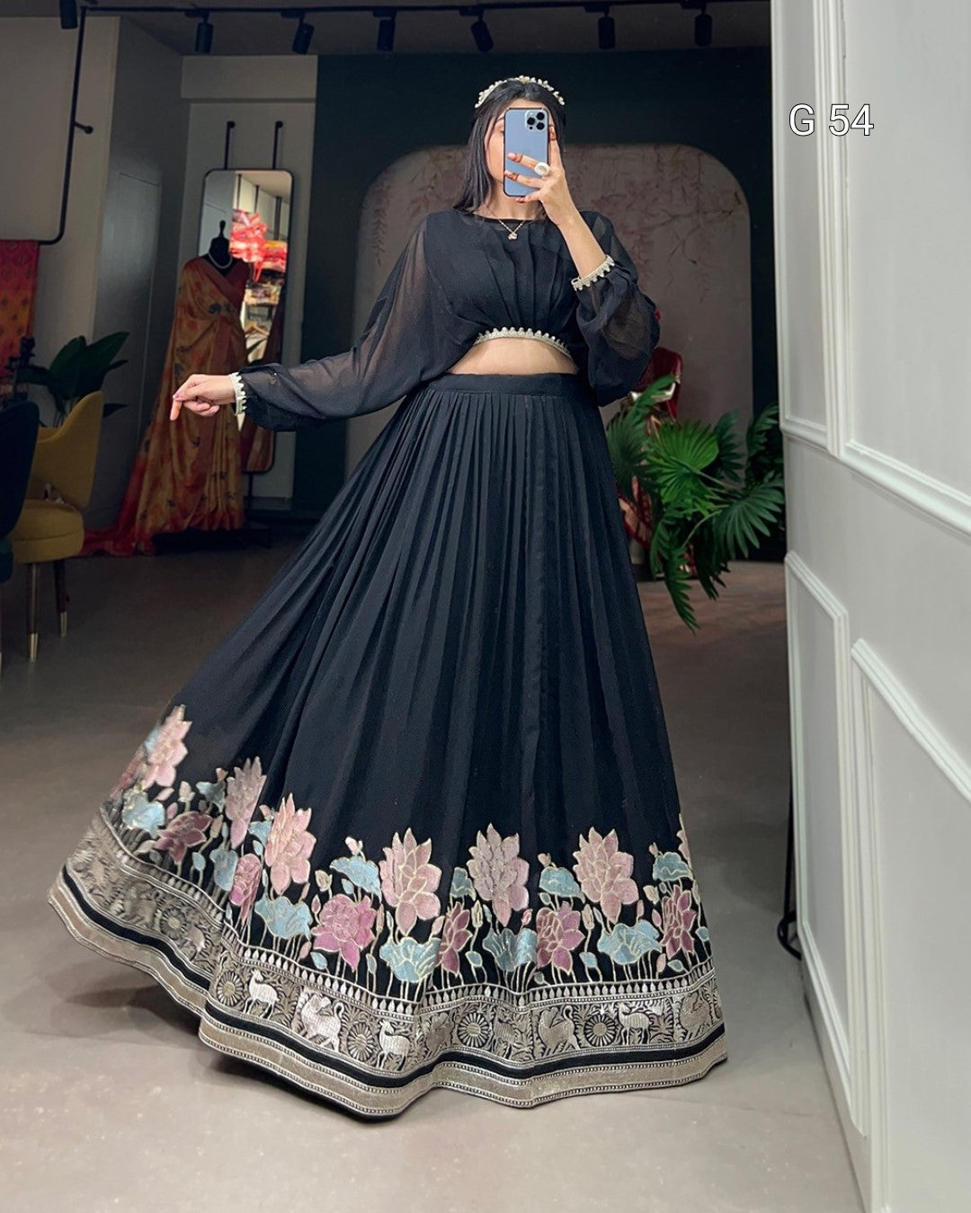 Navy blue traditional outfit with floral embroidery on a plain background