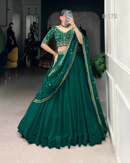 Green embroidered traditional outfit with a matching dupatta on a neutral background
