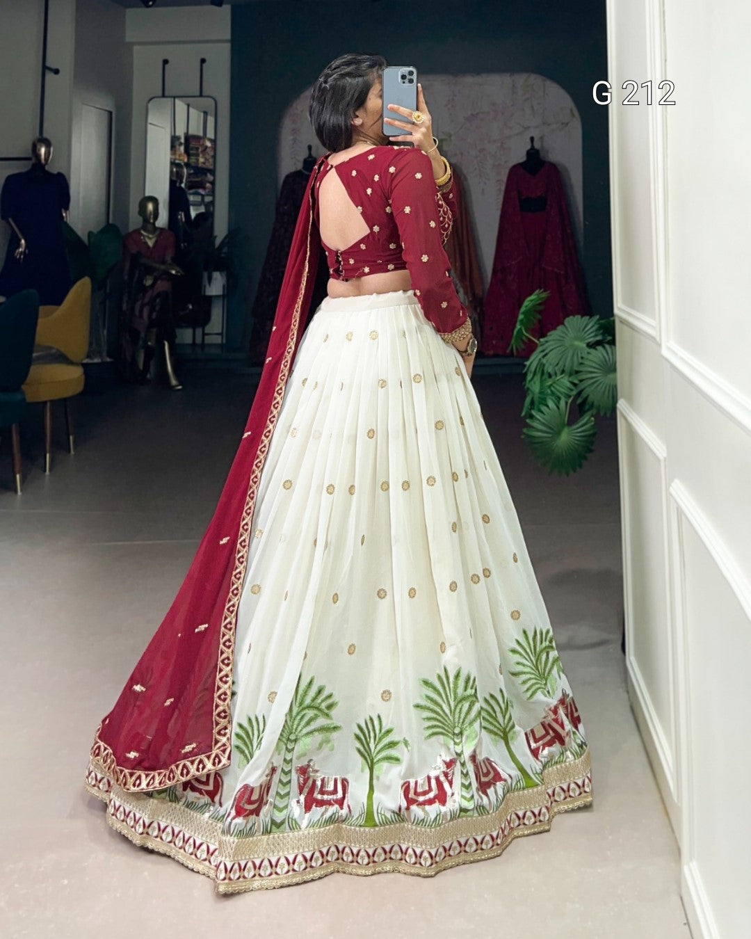 Woman in a red and white embroidered traditional outfit taking a mirror selfie.