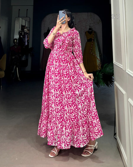 Person wearing a pink and white patterned dress standing in a room.