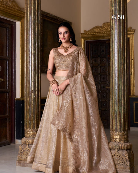 Woman in a traditional beige embroidered outfit standing in an ornate room.