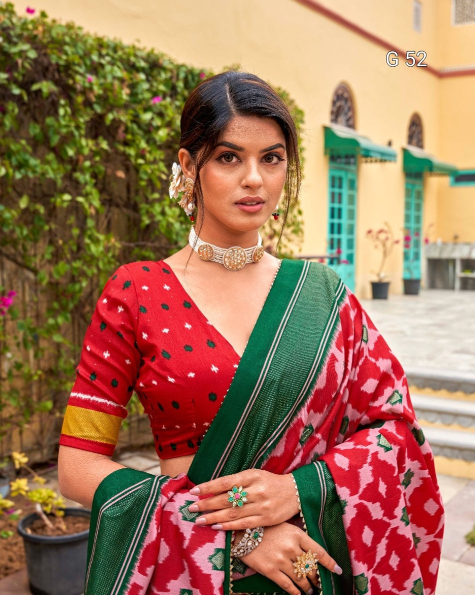 Woman in a red and green saree with a traditional setting
