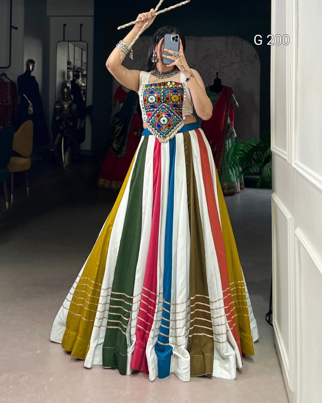 Person wearing a colorful traditional outfit with a striped skirt in a room.
