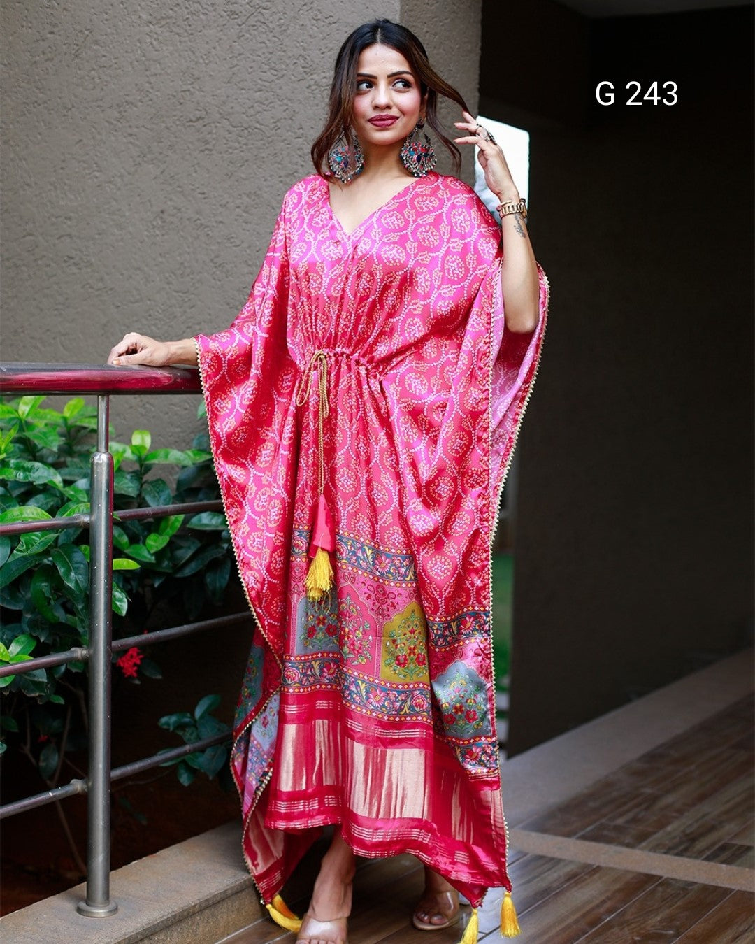 Woman wearing a pink patterned dress standing outdoors.