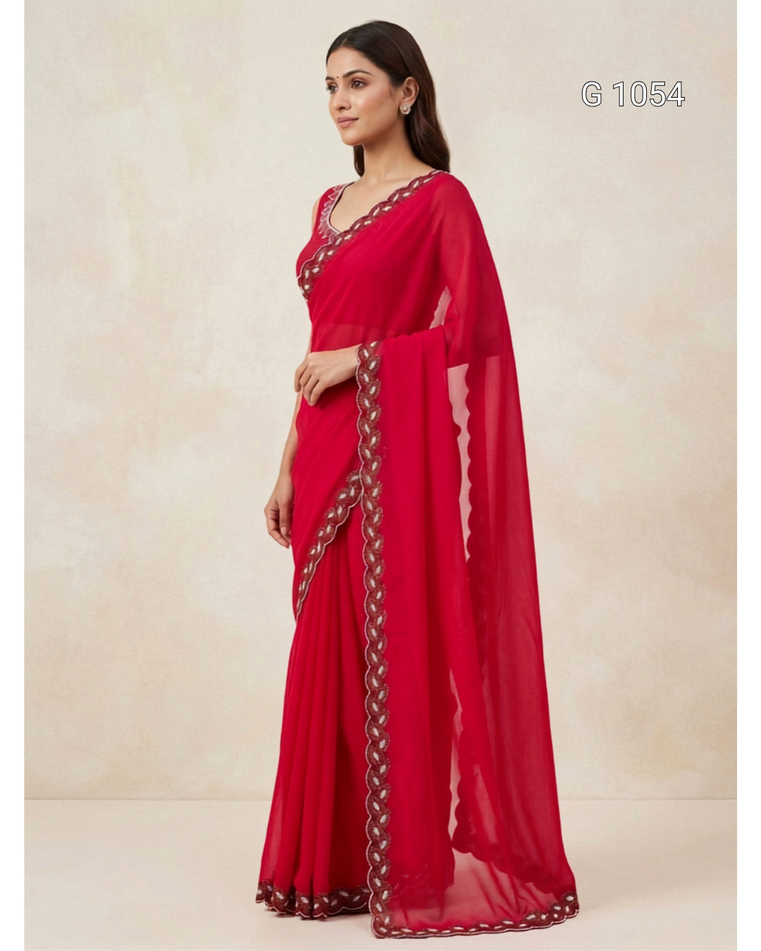 A woman modeling a bright red georgette saree with a matching blouse and dupatta, featuring a decorative border with metallic embroidery. The image is shot against a neutral beige textured backdrop with a style code 'G 1054' in the top right corner.