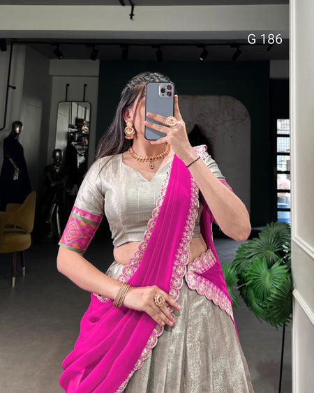 Person wearing a traditional outfit with a pink saree and silver blouse, taking a mirror selfie.