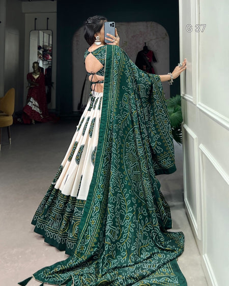 Woman in a green and white saree with a patterned design, standing in a room.