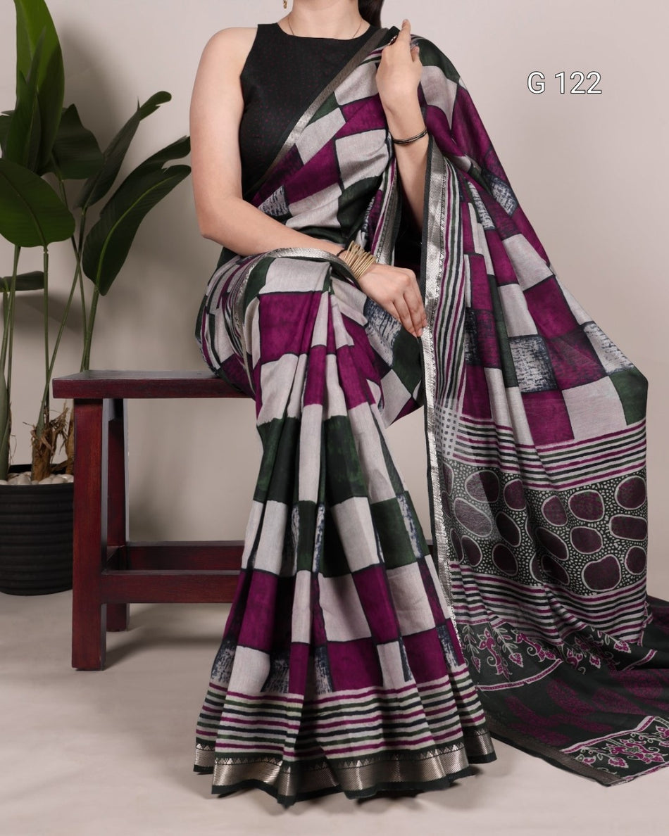Woman wearing a patterned saree with a plant in the background