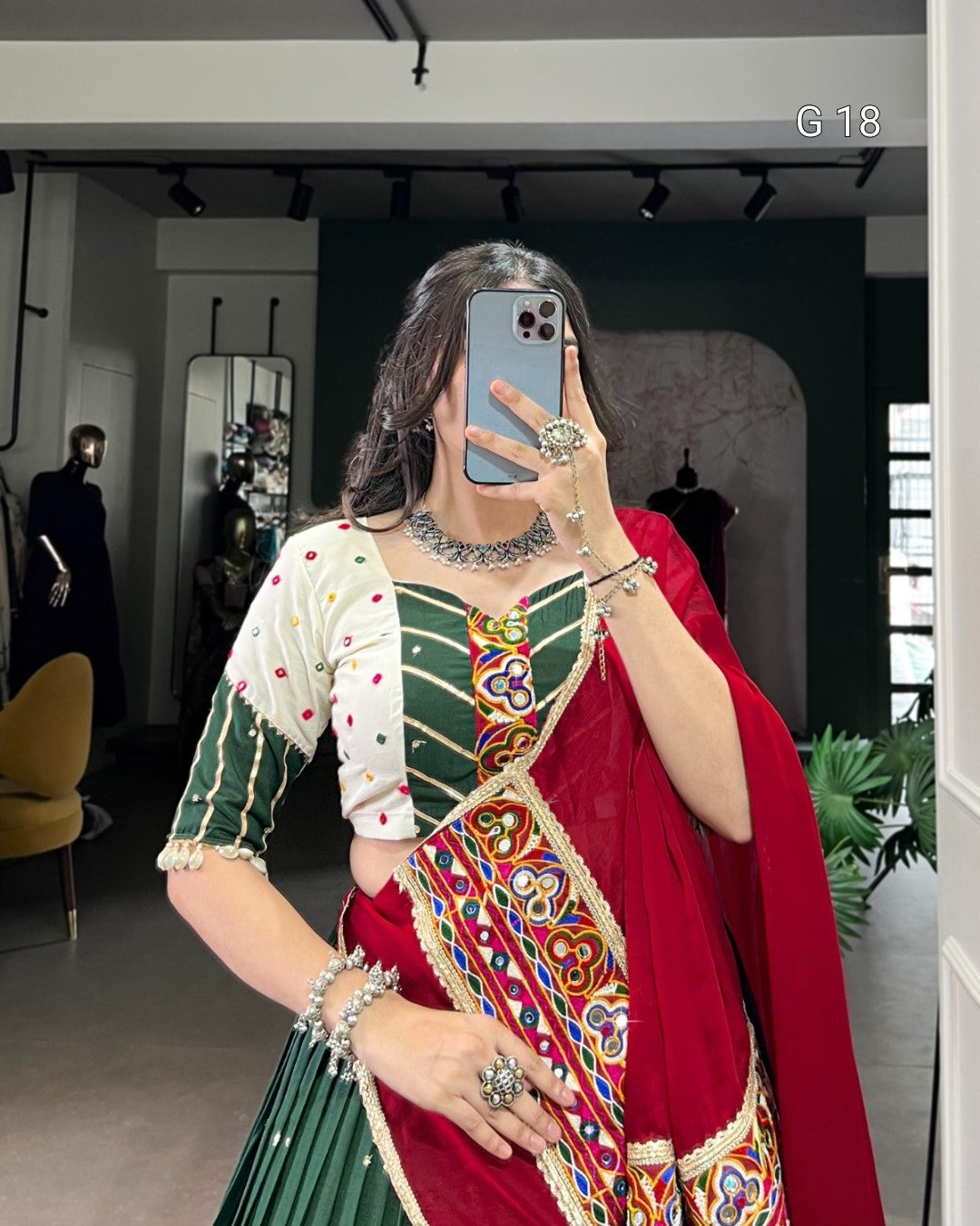 Person wearing a traditional outfit with a colorful saree in a mirror selfie.