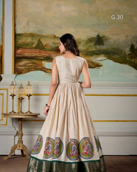 Woman in a beige dress with floral patterns standing in a room with a painting on the wall.