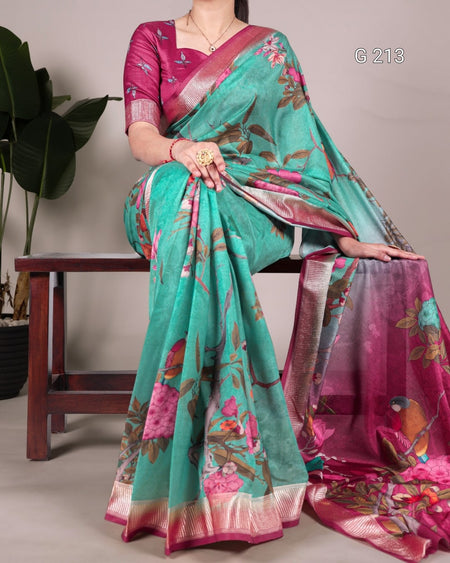 Woman wearing a teal and pink saree with floral patterns, sitting on a chair.