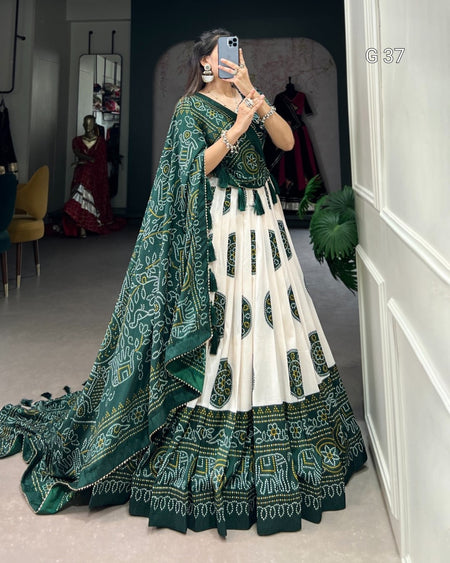 Woman in a green and white traditional outfit taking a mirror selfie.