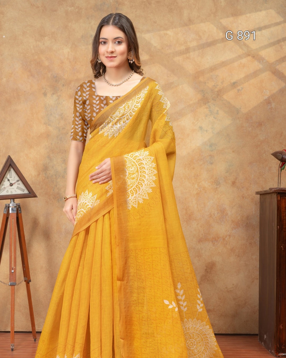Woman wearing a yellow saree with white embroidery against a brown background