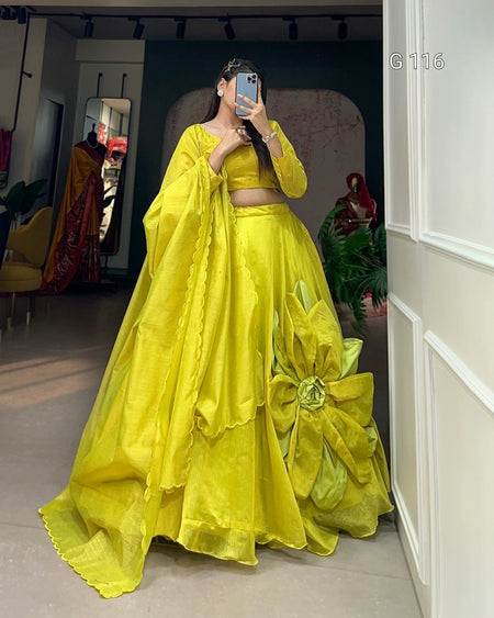 Person wearing a bright yellow traditional outfit with a large bow in a room.