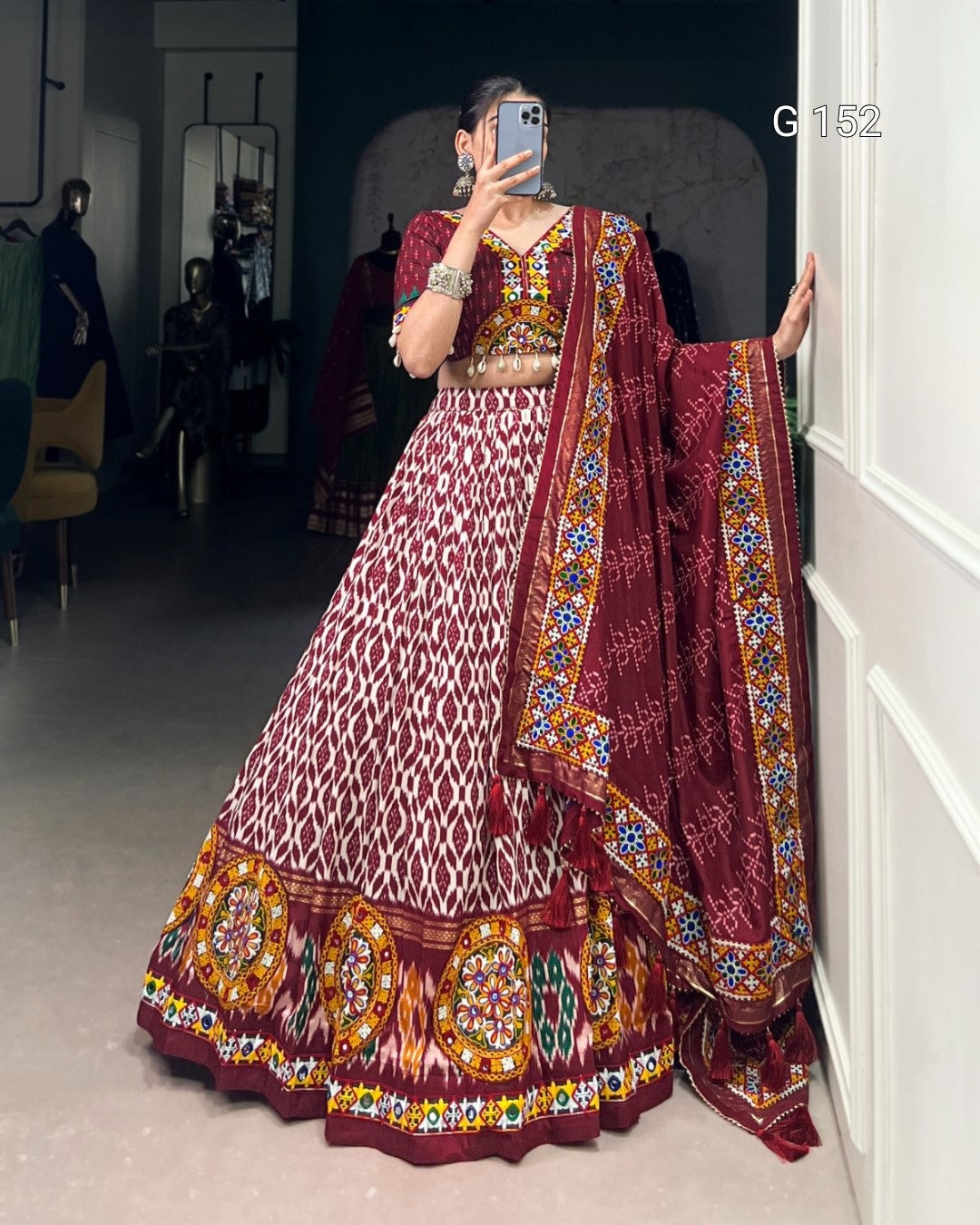 Person wearing a traditional maroon and white embroidered outfit with a matching dupatta.