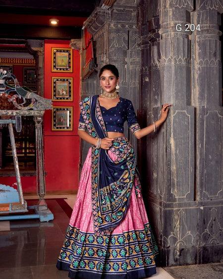 Woman in a traditional outfit standing against a decorative wall.