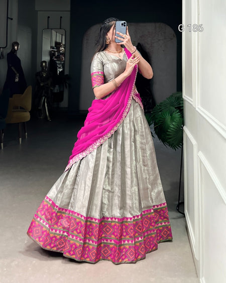 Woman taking a mirror selfie wearing a traditional outfit with a pink and gray color scheme.