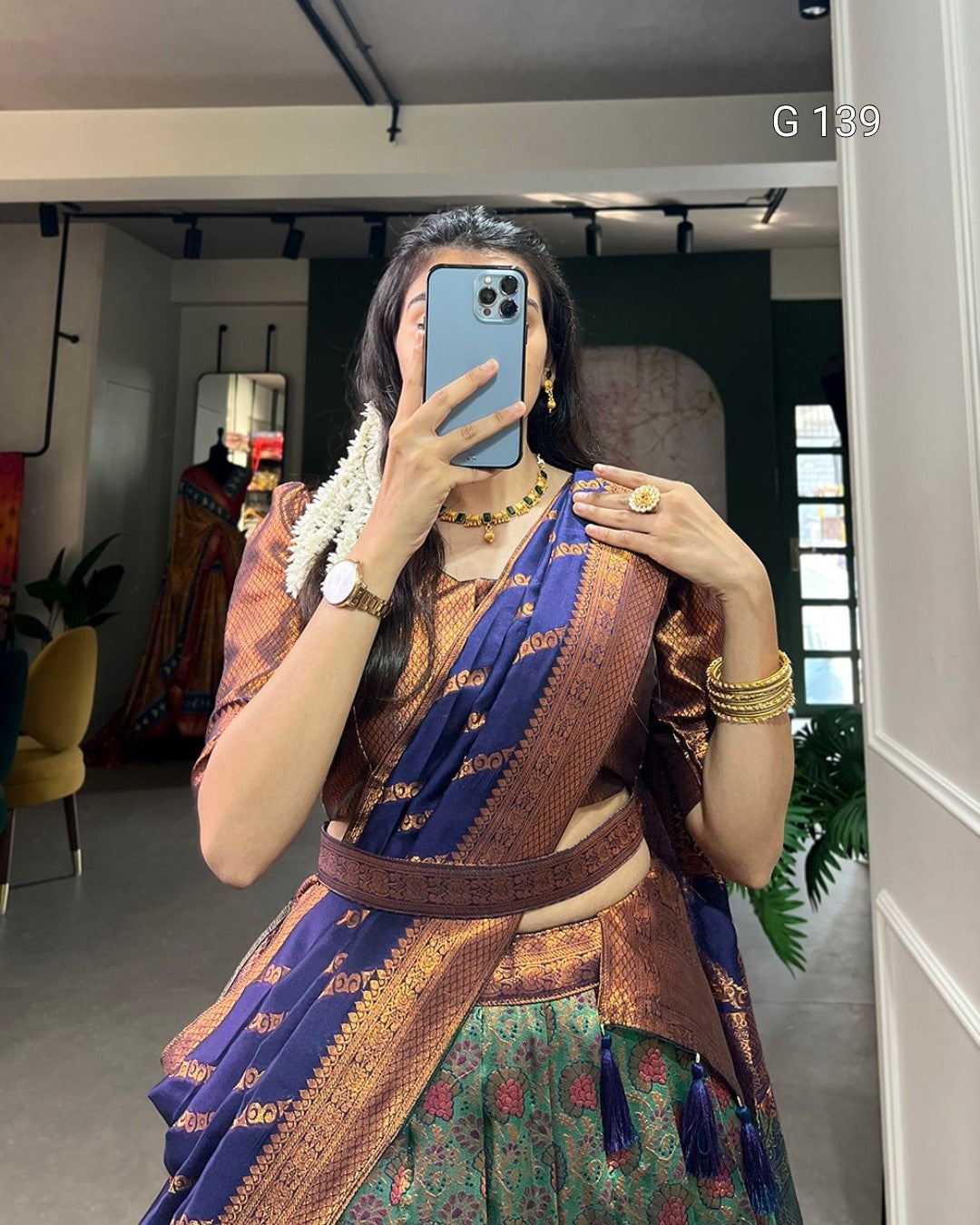 Person wearing a traditional saree with jewelry indoors.