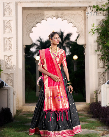 Woman in a traditional outfit standing in front of an ornate archway.