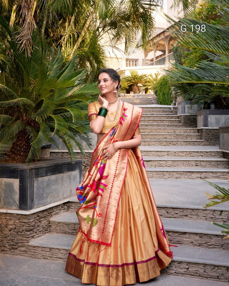 Woman in a traditional saree standing outdoors with greenery and steps in the background