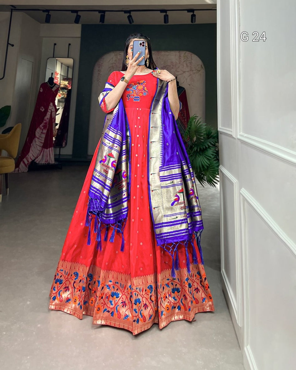 Person wearing a red and blue embroidered traditional outfit in a room.