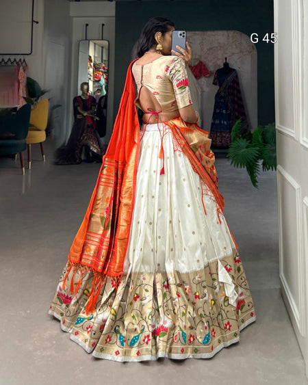 Woman in a traditional outfit with orange dupatta taking a mirror selfie.