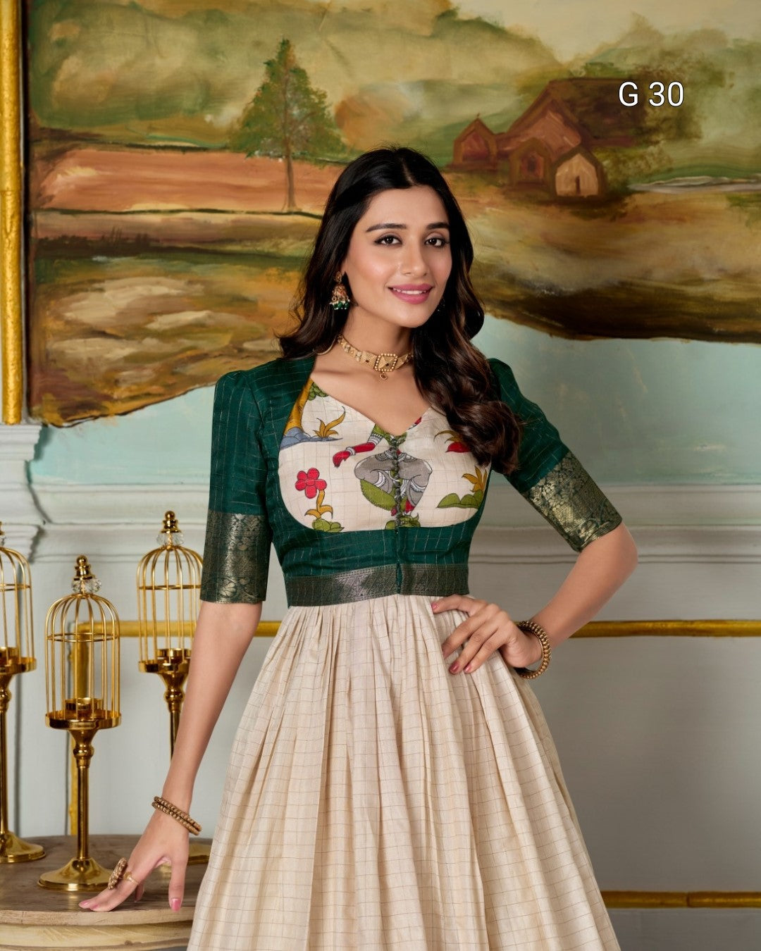Woman in a traditional outfit standing in front of a decorative wall with a painting.