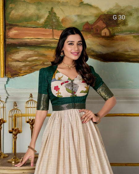 Woman in a traditional outfit standing in front of a decorative wall with a painting.