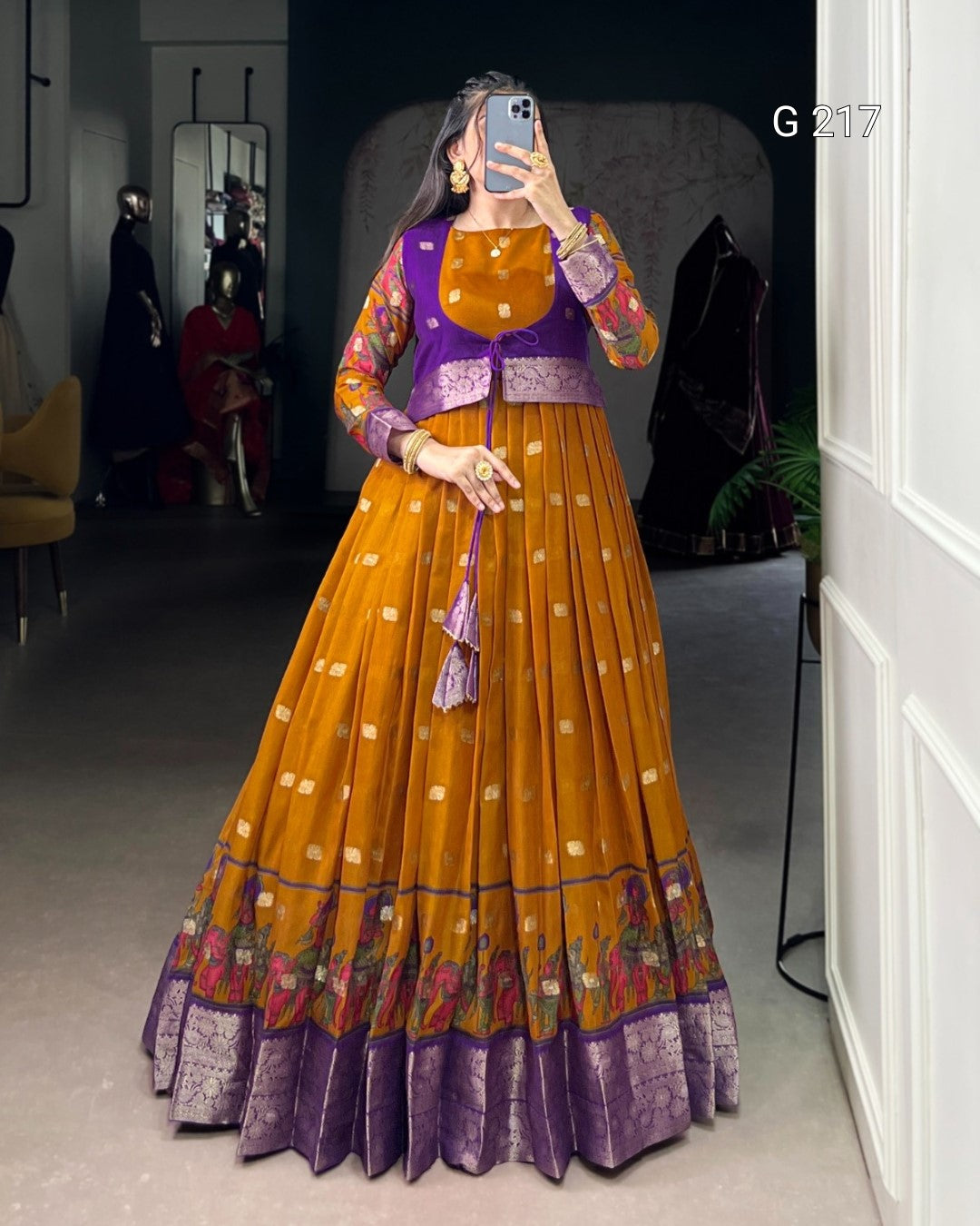 Person wearing a traditional outfit with a purple top and orange skirt in a room.