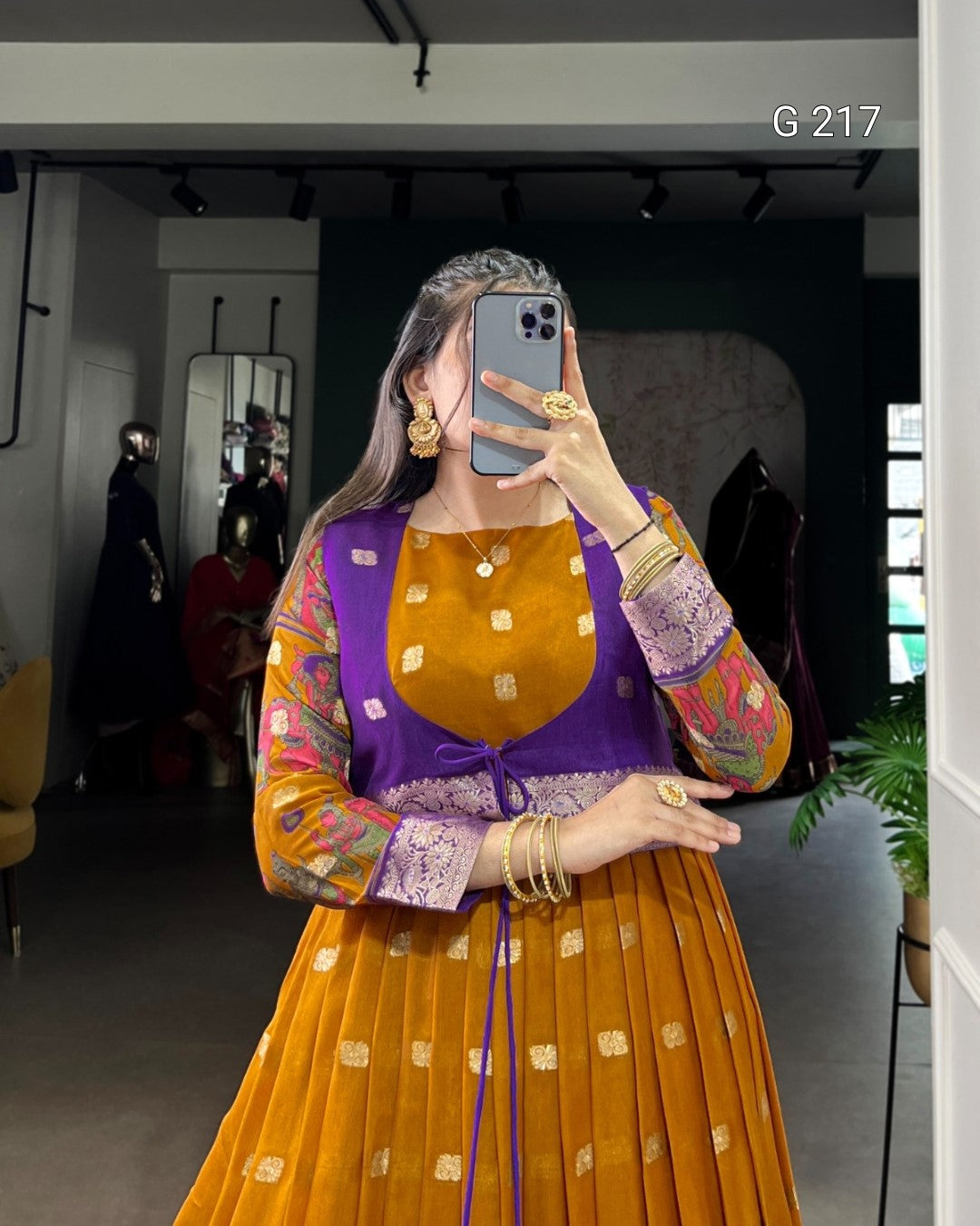Person wearing a colorful outfit with a purple top and orange skirt, taking a mirror selfie.