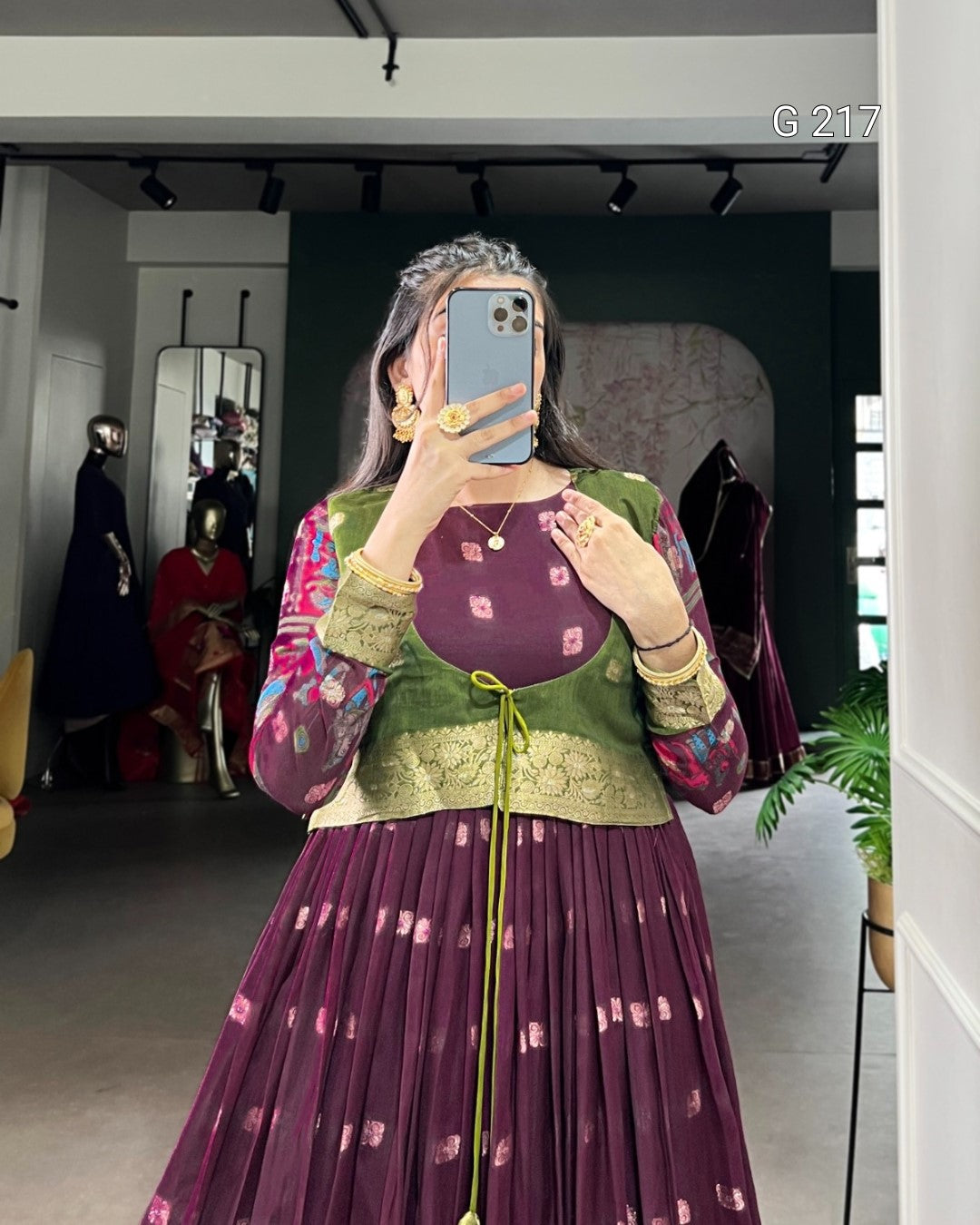 Person wearing a colorful traditional outfit with a patterned dress and top, standing in a room.