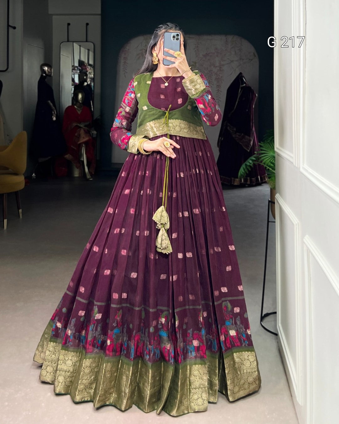 Person wearing a traditional outfit with a purple and green dress in a room setting.