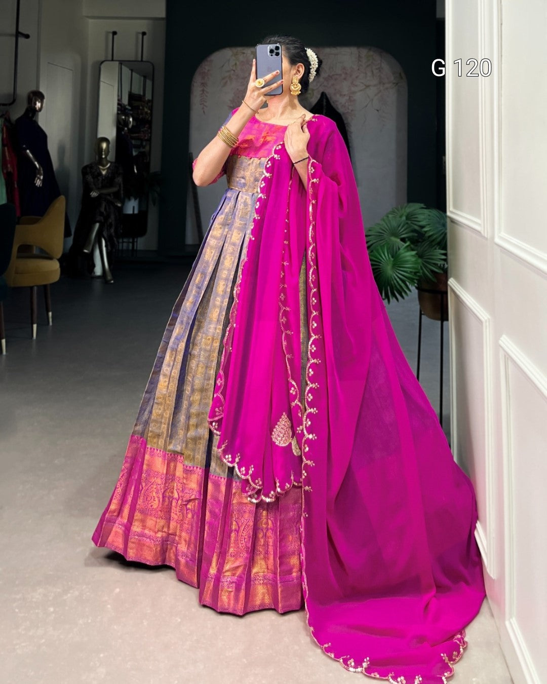 Person wearing a pink saree with a gold border in a room setting.