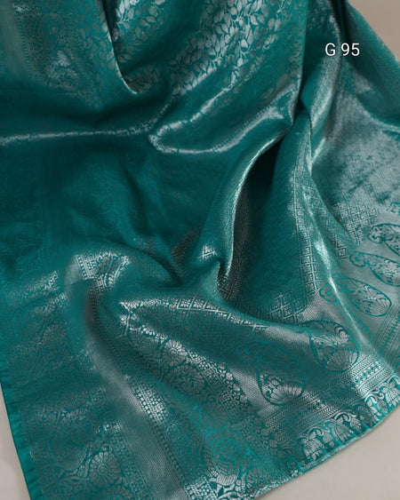 Teal fabric with intricate patterns on a plain background