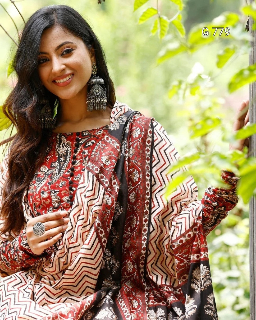 Woman wearing a patterned outfit with a blurred green background
