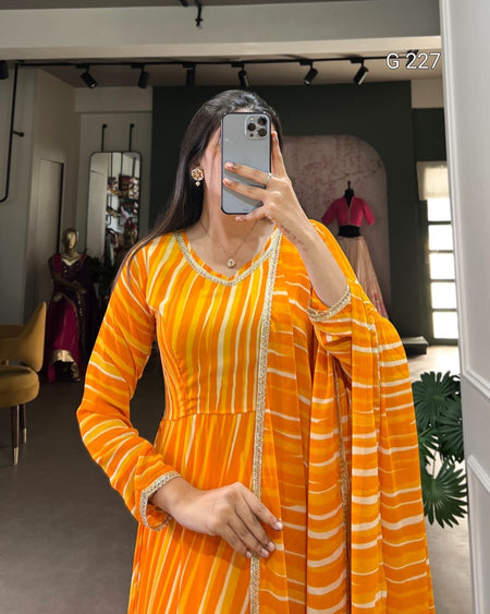 Person wearing an orange and white striped dress taking a mirror selfie.